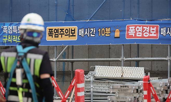 서울의 한 공사 현장에 폭염 관련 주의 현수막이 설치돼 있다. 연합뉴스