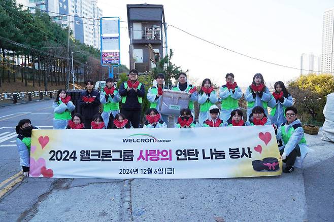 6일 인천 학익동 일대에서 연탄나눔 봉사활동에 나선 웰크론그룹 직원들이 기념촬영을 하고 있다.(사진=웰크론)