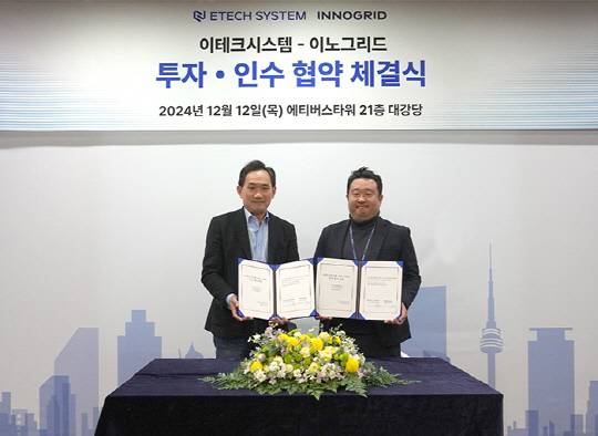 김군도(왼쪽) 이테크시스템 대표와 김명진 이노그리드 대표가 서울 중구 에티버스타워에서 투자·인수 계약을 맺고 기념촬영하고 있다. 에티버스 제공