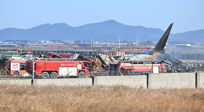 29일 오전 전남 무안공항에서 착륙 도중 충돌로 추정되는 사고가 난 여객기 주변 화재 현장 소방 당국의 구조 활동이 진행되고 있다.뉴시스