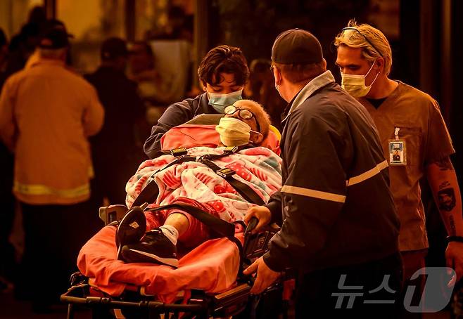 소방대원들이 8일 (현지시간) 캘리포니아주 패서디나의 병원으로 환자를 이송하고 있다. 2025.01.09 ⓒ AFP=뉴스1 ⓒ News1 우동명 기자