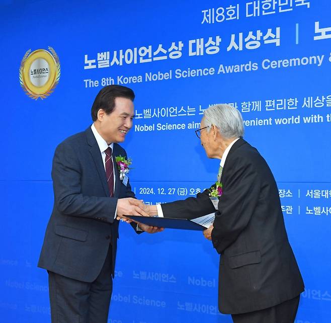 하나님의 교회 총회장 김주철 목사(왼쪽)가 조완규 한국노벨사이언스위원회 명예고문(前 서울대 총장)으로부터 교회를 대표해 세계평화봉사대상을받으며 악수를 하고 있다.