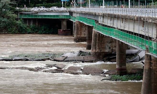 2020년 8월 발생한 춘천 의암댐 선박 전복 사고와 관련, 사고 이후 의암댐 인근 신연교 교각에 떠내려 온 수초섬이 걸려 있는 모습. 연합뉴스