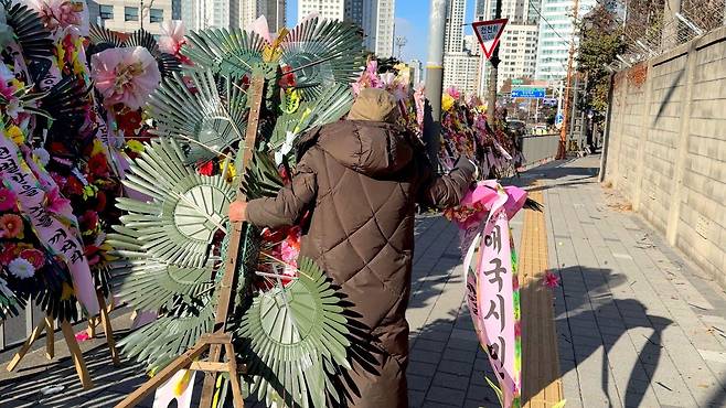 70대 여성 A씨는 영하 12도를 기록한 9일 오전 한남동 대통령실 인근의 화환을 정리하고 있었다