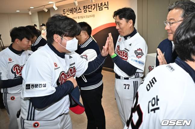 박석민(왼쪽) 두산 베어스 코치가 15일 잠실구장에서 열린 두산 베어스의 창단 기념식에서 이승엽(오른쪽에서 두 번째) 두산 감독과 하이파이브를 하고 있다.