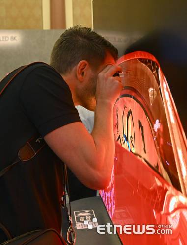 삼성전자는 5일(현지시간) 미국 라스베이거스에서 개막하는 CES 2025를 앞두고 시저스팰리스 호텔에서 '삼성 퍼스트 룩 2025' 행사를 열었다. 해외 미디어 관계자가 OLED TV를 확대경으로 자세히 보고 있다. 라스베이거스=박지호기자 jihopress@etnews.com