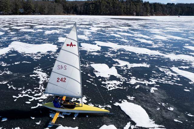 미국 매사추세츠주 브룩필드에서 15일 한 요트클럽 회원이 꽁꽁 얼어붙은 쿼보그 연못 위 아이스 요트를 타고 있다. 두께 15cm가 넘는 얼음과 최대 시속 40kph의 돌풍을 동반한 바람으로 금속 칼날에 나무와 탄소섬유로 만든 아이스보트는 시속 180km/h의 속도를 낼 수 있다. 브룩필드=EPA 연합뉴스