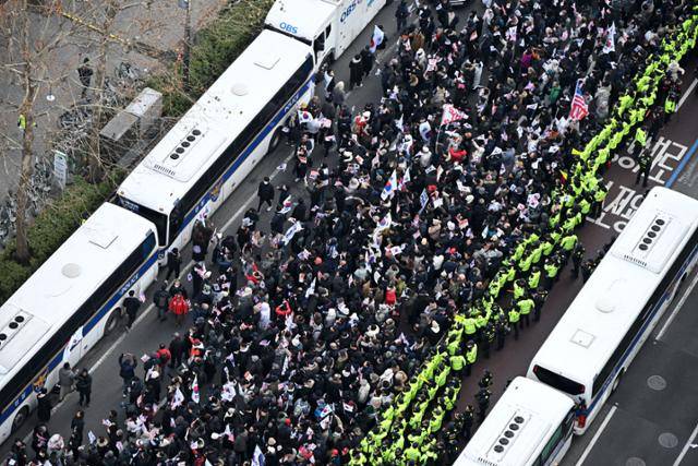 내란 우두머리 혐의로 체포된 윤석열 대통령의 구속 전 피의자심문(영장실질심사)이 열린 18일 서울 마포구 서울서부지방법원 앞에서 윤 대통령 지지자들이 집회를 하고 있다. 사진공동취재단