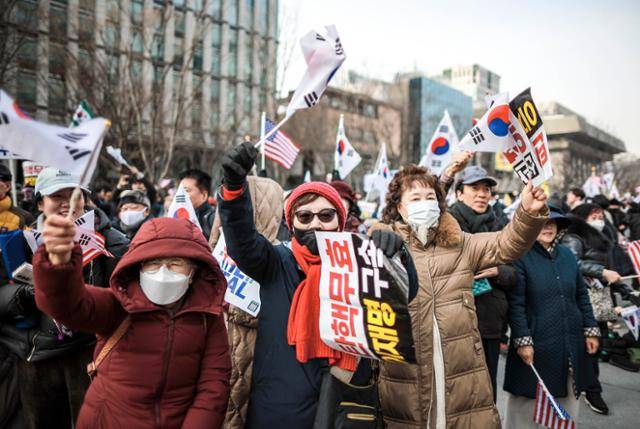 윤석열 대통령 탄핵 반대 집회 참가자들이 18일 서울 종로구 동화면세점 인근에서 태극기와 성조기를 흔들며 구호를 외치고 있다. 뉴시스