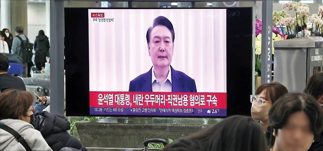 윤석열 대통령이 구속된 19일 시민들이 인천국제공항 제1터미널 입국장에서 관련 속보를 지켜보고 있다. 뉴스1