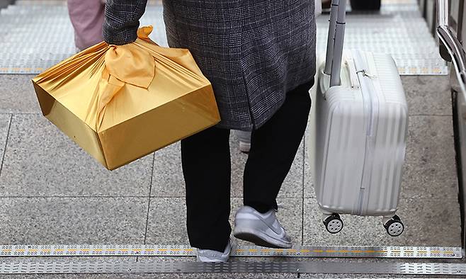 설 연휴 둘째 날인 26일 서울역에서 한 귀성객이 선물 보따리를 들고 승차장으로 향하고 있다. 연합뉴스