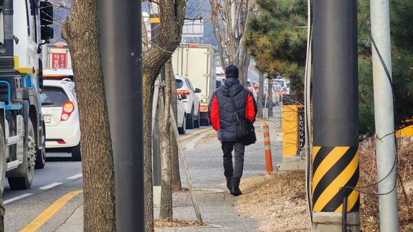 21일 오전 10시께 광주시 신현동의 한 보행로에 가로수와 고정 지지대가 인도의 절반 이상을 차지하고 있는 가운데 보행자가 인도 옆 화단을 통해 걷고 있다. 한준호기자