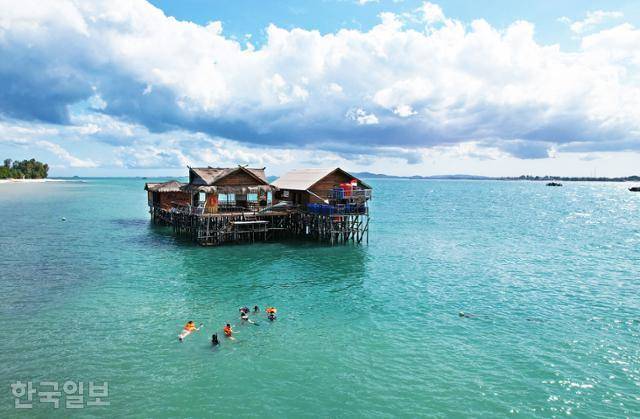 싱가포르 여행객들이 인도네시아 빈탄의 수상가옥 주변 바다에서 스노클링을 즐기고 있다.