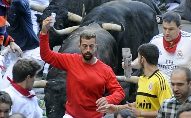 스페인 투우 행사에서 사진을 찍기 위해 황소 앞에 몸을 던지는 사람들. 사진=AFP 연합뉴스