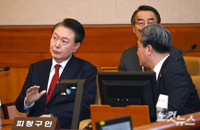 윤석열 대통령이 6일 오전 서울 종로구 헌법재판소 대심판정에서 열린 탄핵심판 6차 변론기일에 출석해 변호인단과 대화를 나누고 있다. 사진공동취재단