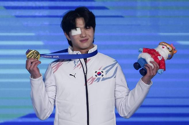 8일 열린 메달 세리머니에서 멍이 든 눈을 안대로 가리고 시상대에 오른 이승훈. 하얼빈=AP 뉴시스