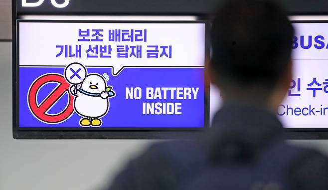 부산 강서구 김해국제공항 국제선 에어부산 출국장 전광판에 나오는 보조배터리 기내 선반 탑재 금지 안내문. /뉴스1