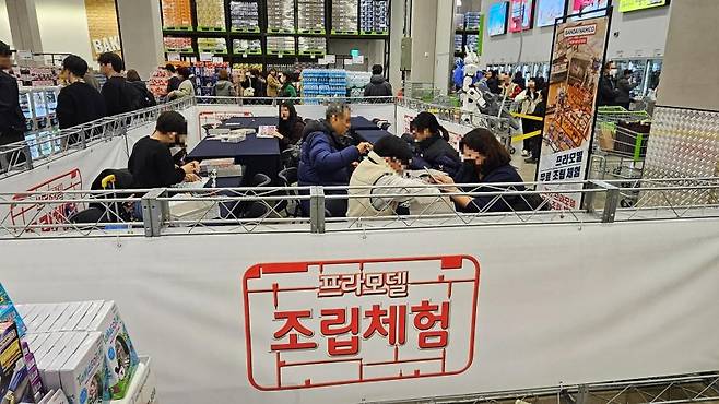 지난 14일 오후 서울 강서구 이마트 트레이더스 홀세일클럽 마곡점 오픈 첫날 건담 로드쇼에서 사람들이 제품 조립을 체험해 보고 있다. 사진=노유정 기자