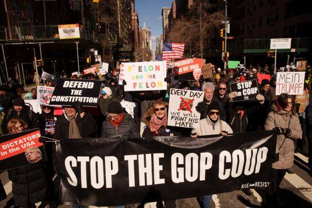 17일 미국 뉴욕에서 '대통령의 날, 왕은 없다' 집회에 참석한 시위대가 도널드 트럼프 대통령과 일론 머스크 테슬라 최고경영자를 비판하는 팻말을 들고 행진하고 있다. 뉴욕=로이터 연합뉴스