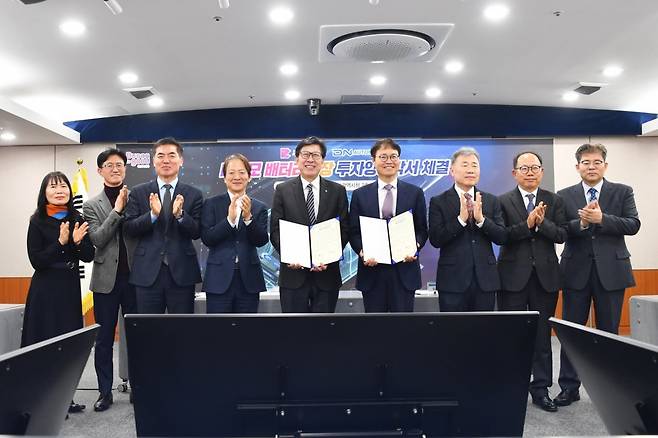 20일 부산시에서 열린 부산시와 디엔오토모티브 투자 양해각서 체결식에서 박형준 부산시장(왼쪽 다섯 번째)과 김상헌 디엔오토모티브 대표(왼쪽에서 여섯 번째)가 4400억 규모 신규 배터리 공장 신설을 위한 양해각서를 펼쳐 보이며 활짝 웃고 있다. 부산시 제공