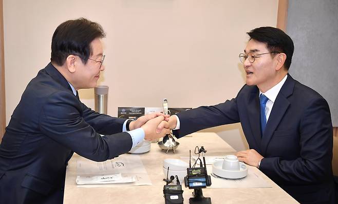 이재명 더불어민주당 대표와 박용진 전 의원이 21일 서울 여의도의 한 식당에서 만나 대화를 하던 중 악수하고 있다. /뉴스1
