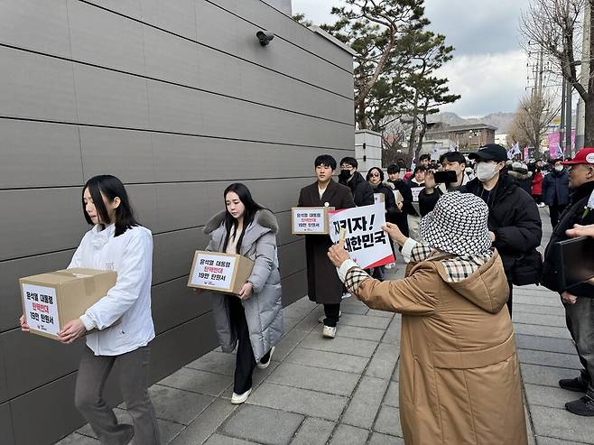 대통령 국민변호인단 소속 인원들이 탄핵반대 탄원서 상자를 들고 헌법재판소 민원실로 이동하고 있다. 정봉비 기자
