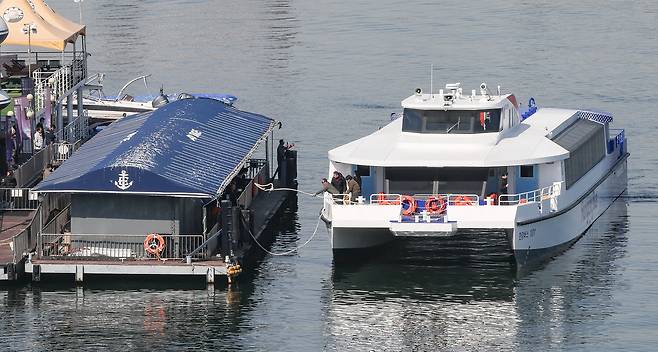 한강 수상교통 수단인 한강버스가 27일 서울 여의도 선착장 진성나루에 도착해 관계자가 정박용 로프를 던지고 있다.
