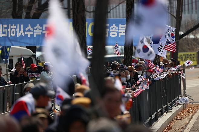 법원의 윤석열 대통령 구속 취소 결정을 두고 검찰의 입장 발표가 늦어지고 있는 가운데 8일 경기도 의왕시 서울구치소 앞에서 윤 대통령 지지자들이 석방을 기대하며 태극기와 성조기를 흔들고 있다. 연합뉴스