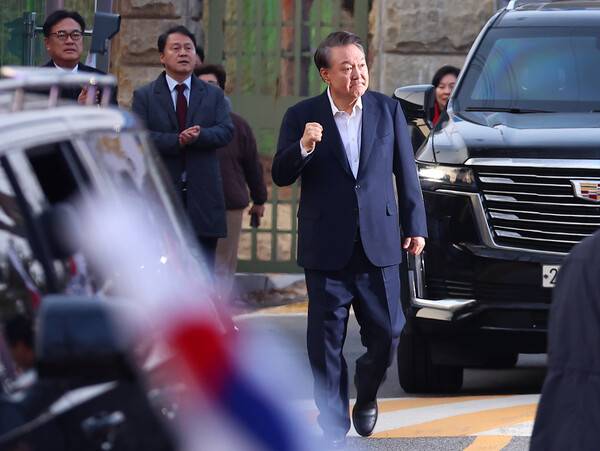 윤석열 대통령이 8일 경기도 의왕시 서울구치소 앞에서 경호 차량에서 내려 지지자들에게 인사하며 주먹을 불끈 쥐어보이고 있다. 연합뉴스