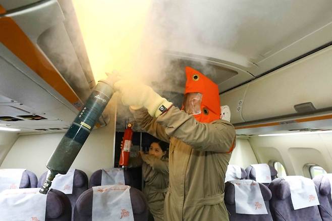 제주항공 객실승무원들이 지난 4일 객실훈련센터에서 기내 화재를 대비한 화재 진압 및 승객 안전 확보 훈련을 하고 있다. (제주항공 제공)