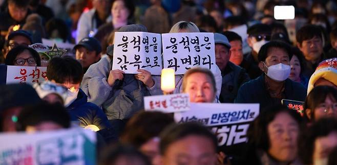 윤석열 대통령 즉각 파면을 촉구하는 야5당 공동 사전 집회가 서울 종로구 광화문 일대에서 열린 13일 저녁 참석자들이 손팻말을 들고 있다. 김혜윤 기자 unique@hani.co.kr