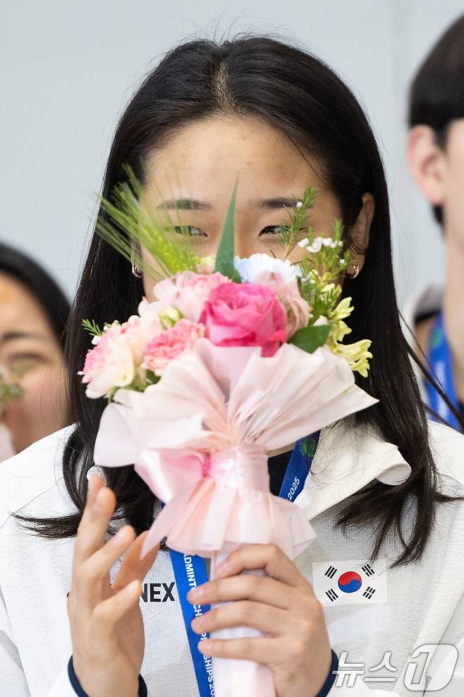 전영 오픈에서 우승을 차지한 배드민턴 안세영이 18일 오후 인천국제공항을 통해 귀국해 기념촬영 중 응원 소리에 쑥스러워하고 있다. 2025.3.18/뉴스1 ⓒ News1 이승배 기자