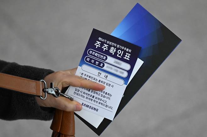 19일 경기도 수원시 영통구 수원컨벤션센터에서 열린 제56기 삼성전자 정기주주총회에서 주주가 주주확인표를 들고 있다. 연합뉴스