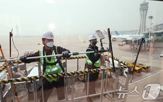 인천공항운영서비스 환경미화운영그룹 직원들이 25일 오전 인천국제공항 제2터미널에서 봄맞이 유리창 물청소를 하고 있다. 2025.3.25/뉴스1 ⓒ News1 장수영 기자