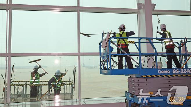인천공항운영서비스 환경미화운영그룹 직원들이 25일 오전 인천국제공항 제2터미널에서 봄맞이 유리창 물청소를 하고 있다. 2025.3.25/뉴스1 ⓒ News1 장수영 기자