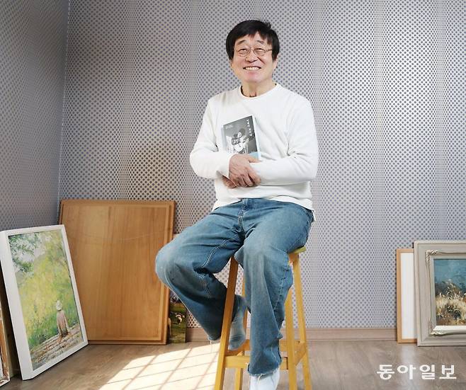 21일 서울 서초구 자택에서 만난 가수 김창완이 30년 전 펴낸 첫 산문집을 개정한 책 ‘이제야 보이네’를 들어 보이며 웃고 있다. 청년들이 꼽는 ‘닮고 싶은 어른’ 중 한 명인 그는 “청년의 결핍도 희망의 씨앗이 될 수 있다”고 격려했다. 신원건 기자 laputa@donga.com
