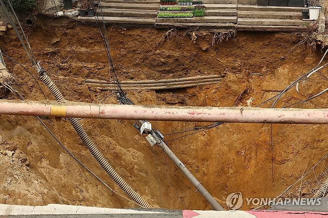 서울 한복판에 발생한 대형 땅꺼짐 (서울=연합뉴스) 서대연 기자 = 25일 강동구 대명초등학교 도로에서 전날 발생한 대형 땅꺼짐 현장의 모습.
전날 오후 명일동 대명초등학교 인근 사거리에서 발생한 지름 20m, 깊이 18m가량의 대형 싱크홀(땅꺼짐)에 오토바이 운전자 1명이 빠져 실종됐다. 2025.3.25 dwise@yna.co.kr