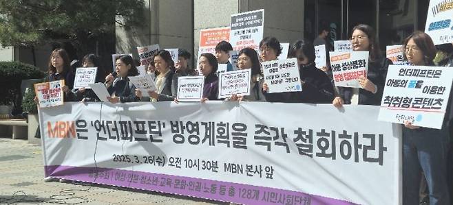 여성·언론·청소년·교육 등 분야의 129개 시민 사회 단체가 26일 오전 서울 MBN 본사 앞에서 기자회견을 열어 ‘언더피프틴’ 방영 계획을 철회하라고 촉구하고 있다. 사진 속에는 128개 단체라고 돼 있으나 최종 129곳이 참여했다. 한국여성단체연합 제공