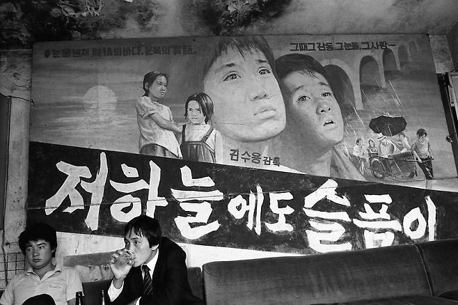 1985년 폐업한 남포동 동명극장 간판이 사람들 뒤로 걸려 있다./ 사진가 문진우