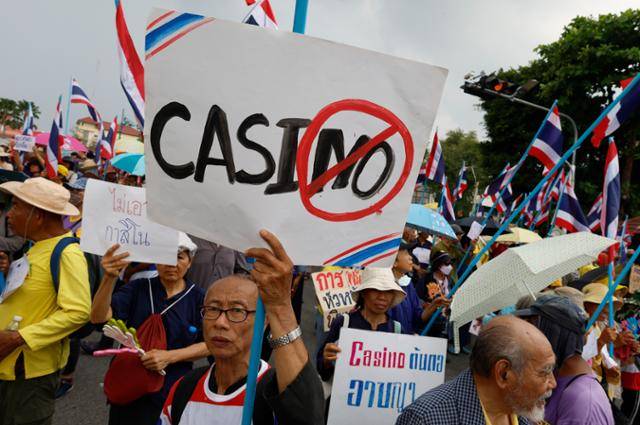 27일 태국 방콕 정부청사 앞에서 정부의 카지노 합법화 추진을 반대하는 시위대가 팻말을 들고 있다. 방콕=EPA 연합뉴스