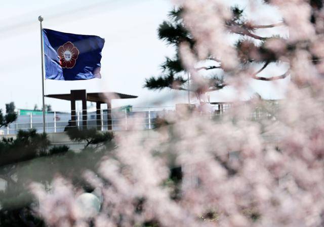 헌법재판소의 윤석열 대통령 탄핵심판 선고가 이번 주를 넘기면서 4월로 넘어갈 가능성이 커진 가운데 28일 오후 서울 종로구 재동 헌법재판소 경내에 활짝 핀 벚꽃 뒤로 헌재기가 바람에 펄럭이고 있다. 뉴스1