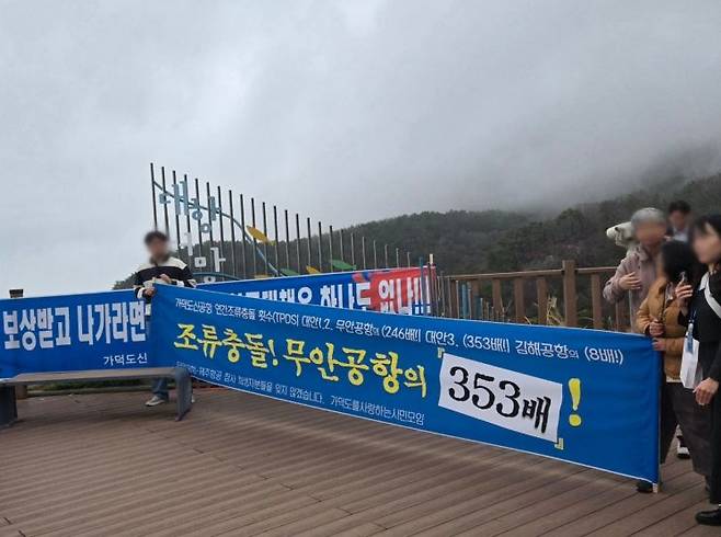 27일 부산 강서구 가덕도 대항전망대에서 기자단 대상 가덕도신공항 건설사업 설명회가 열린 가운데 시민들이 현수막을 들고 신공항 내 조류충돌 위험성을 알리고 있다. 최서윤 기자