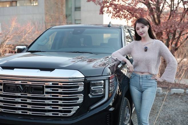 나연진 앵커가 'GMC 시에라 드날리' 차량 옆에서 포즈를 취하고 있다. 사진=글로벌 모빌리티 이병주 PD