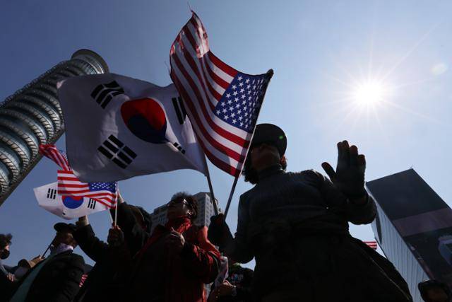 지난달 22일 서울 중구 세종대로에서 열린 '윤석열 대통령 탄핵반대 광화문국민대회'에서 참가자들이 태극기와 성조기를 흔들고 있다. 연합뉴스