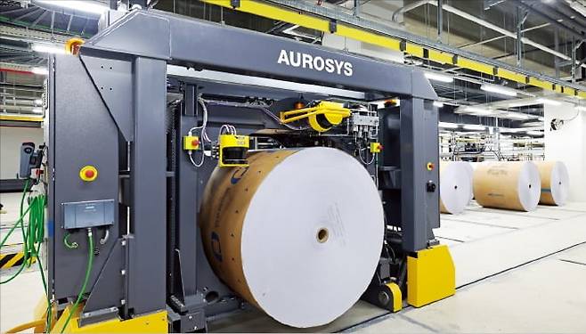 < 로봇으로 옮긴 용지 > 한국경제신문의 인천 부평 윤전공장에는 로봇, 센서 등 자동화 기술이 대거 적용됐다. 둘둘 말린 신문 용지가 자동이동설비 안으로 들어가고 있다. 최혁 기자