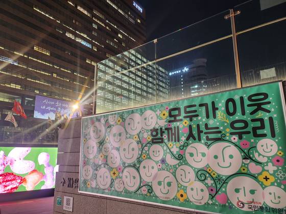 지난 2월 시위대가 행진하는 광화문광장 한쪽에 ‘모두가 이웃, 함께 사는 우리’라는 문구가 보인다. 전수진 기자