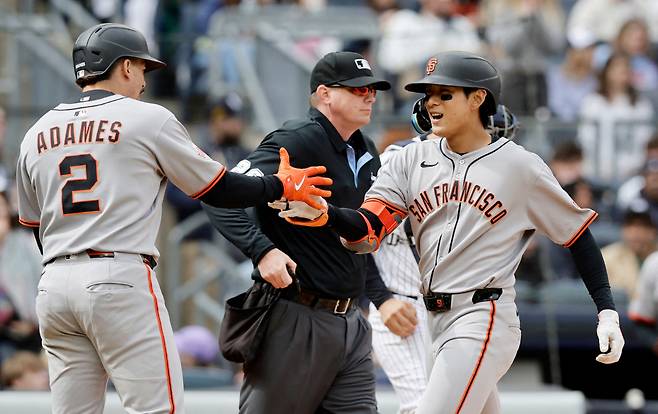 이정후가 6회 역전 홈런포를 터뜨리고 들어와 윌리 아다메스와 손을 맞잡고 있다. AFP연합뉴스