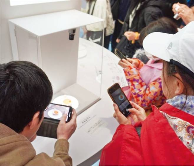 < 만능세포로 만든 심근 시트 > 14일 일본 바이오기업 쿠오립스가 오사카·간사이 엑스포 ‘오사카 헬스케어관’에 전시한 ‘심근 시트’를 관람객들이 보고 있다. 쿠오립스는 유도만능줄기세포(iPSC)로 키운 심장근육 세포를 가공해 만든 이 심근 시트를 지난 8일 일본 후생노동성에 제조·판매 신청했다. 김일규 특파원