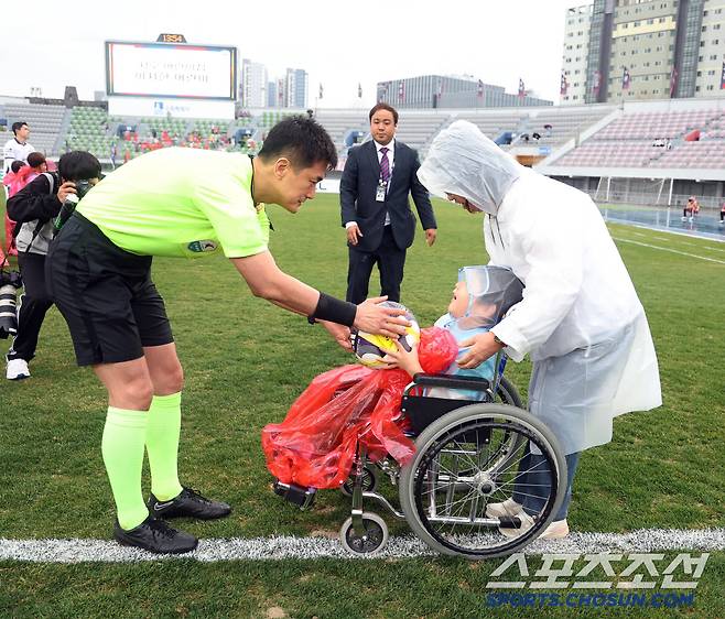 고형진 주심(왼쪽)이 12일 수원종합운동장에서 열린 K리그1 수원FC-김천상무전에서 장애아전문 시립서호어린이집 이지호군으로부터 매치볼을 전달받고 있다. 사진제공=수원FC