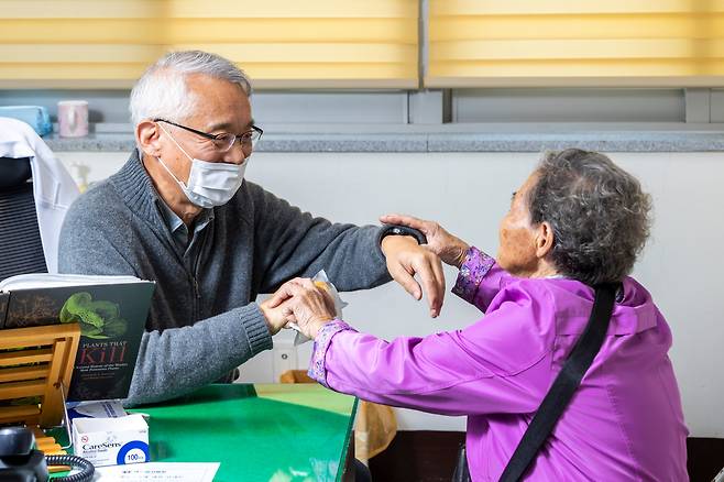 /이신영 영상미디어 기자인터뷰하는 동안 환자 두 명이 찾아왔다. 임경수 소장이 이모(93) 할머니 손을 잡고 진료를 하고 있다.